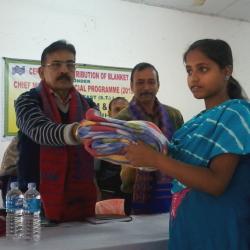 Madhav Prasad Sarma, Kokrajhar DC giving away blanket to a beneficiary at a programme in Kokrajhar, on Wednesday