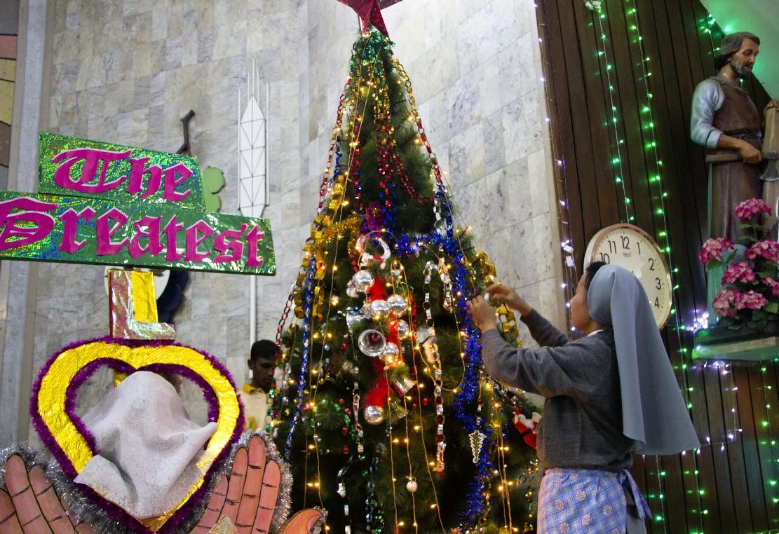 A Nun giving final touch to a Christmas tree at Don Bosco Catholic Church, Guwahati