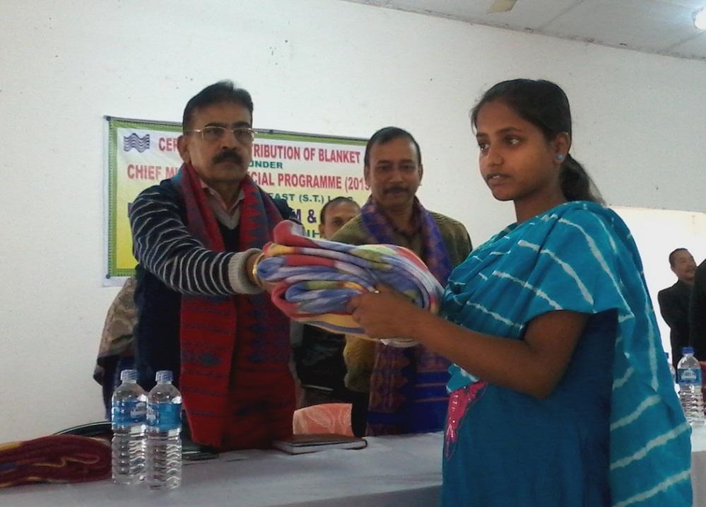 Madhav Prasad Sarma, Kokrajhar DC giving away blanket to a beneficiary at a programme in Kokrajhar, on Wednesday